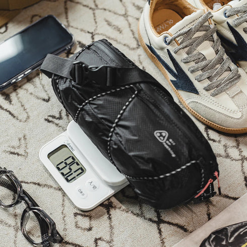 Black glove on a digital scale with a sneaker and phone in the background on a textured surface